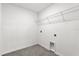 The functional laundry room features tile flooring and a wire shelf for storage at 219 Ash Way, Auburndale, FL 33823