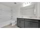 A bathroom features dual vanities, a shower-tub combo, and stylish modern fixtures at 528 Carya Way, Auburndale, FL 33823