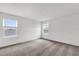 A bright bedroom with neutral carpet, two windows, and white walls offers a calm atmosphere at 528 Carya Way, Auburndale, FL 33823