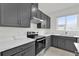 Modern kitchen with stainless steel appliances, gray cabinets, and white countertops at 528 Carya Way, Auburndale, FL 33823