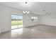 Bright living room with tile floors, chandelier lighting, and sliding doors at 528 Carya Way, Auburndale, FL 33823