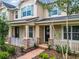 Tan two-story home with white porch and landscaping at 8622 Dufferin Ln, Orlando, FL 32832