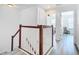 Upstairs hall with wood and white railing staircase, leading to bedrooms and bathroom at 8622 Dufferin Ln, Orlando, FL 32832