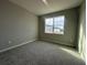 Cozy bedroom featuring neutral walls, carpet and a bright window offering natural light at 5298 Teirgarten St, St Cloud, FL 34771