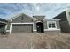 Charming single-story home showcasing a gray facade, a two-car garage, and a brick-paved driveway at 5298 Teirgarten St, St Cloud, FL 34771