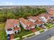 Aerial view showcasing a neighborhood with tile roofs and lush greenery at 13007 Bromborough Dr, Orlando, FL 32832