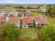 An aerial view shows houses with red tile roofs, green lawns, and ponds in a desirable neighborhood at 13007 Bromborough Dr, Orlando, FL 32832
