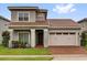 Charming two-story home featuring a well-maintained lawn and a stylish, two-car garage at 13007 Bromborough Dr, Orlando, FL 32832