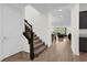 Inviting hallway features a staircase and leads to an open living area with wood-look tile flooring at 13007 Bromborough Dr, Orlando, FL 32832