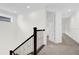 A clean and spacious hallway features staircase with iron railings and neutral colored carpet at 13007 Bromborough Dr, Orlando, FL 32832