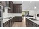 Modern kitchen with stainless steel appliances, dark wood cabinetry, light countertops, and open view to the living room at 13007 Bromborough Dr, Orlando, FL 32832