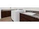 A modern laundry room features updated washer and dryer, dark wood cabinets, and a utility sink at 13007 Bromborough Dr, Orlando, FL 32832