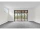 Bright living room featuring neutral carpet, large window and sliding glass doors that leads to covered patio at 13007 Bromborough Dr, Orlando, FL 32832