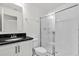 The bathroom is equipped with black granite countertops, white cabinets, a toilet, and a glass shower at 367 Sequoia Dr, Lake Wales, FL 33859