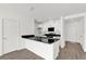 Modern kitchen featuring white cabinetry, black countertops, and sleek appliances at 367 Sequoia Dr, Lake Wales, FL 33859