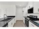 Modern kitchen featuring white cabinetry, black countertops, and sleek appliances at 367 Sequoia Dr, Lake Wales, FL 33859