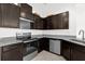 Modern kitchen featuring stainless steel appliances, granite countertops, and dark wood cabinets at 375 Sequoia Dr, Lake Wales, FL 33859