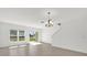 Bright living room with large windows, tile floors and a modern chandelier at 375 Sequoia Dr, Lake Wales, FL 33859