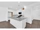 Bright kitchen featuring white cabinets, gray granite counters and island with stainless steel appliances at 410 Sequoia Dr, Lake Wales, FL 33859