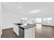 Bright open-concept kitchen featuring modern appliances and a granite countertop island overlooking the living area at 410 Sequoia Dr, Lake Wales, FL 33859