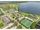 Aerial view of community clubhouse amenities featuring tennis courts, an outdoor pool, and lake access at 4112 Aberdeen Ln, Lake Wales, FL 33859
