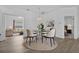 Open-concept dining room with a glass-top table, modern chairs, and views into the living room and bedroom at 4112 Aberdeen Ln, Lake Wales, FL 33859