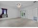 Large carpeted main bedroom with a ceiling fan, white walls, and sliding glass doors at 4112 Aberdeen Ln, Lake Wales, FL 33859