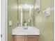 Bathroom featuring a well-lit mirror above the sink, complemented by subtle olive green walls at 497 Lakepark Trl, Oviedo, FL 32765