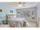 Bedroom with a ceiling fan, large window with shutters, and light blue walls at 5025 St Andrews Arc, Leesburg, FL 34748