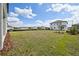 Expansive backyard features green grass and blue skies, providing a peaceful outdoor space at 5714 Cattle Ranch Dr, St Cloud, FL 34771