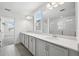Bright bathroom with double sinks, quartz counters, and large mirrors above a bank of neutral vanity cabinets at 5714 Cattle Ranch Dr, St Cloud, FL 34771