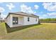 An expansive backyard features lush grass and a covered patio with access from the home via stylish glass paneled double doors at 5715 Cattle Ranch Dr, St Cloud, FL 34771