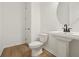 Bright bathroom features wood look flooring and a pedestal sink with updated faucet and white toilet at 5715 Cattle Ranch Dr, St Cloud, FL 34771