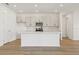 Modern kitchen features white cabinets, an island, stainless steel appliances and wood-look flooring at 5715 Cattle Ranch Dr, St Cloud, FL 34771