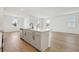 Kitchen island boasts white quartz countertops and stainless steel dishwasher against an open floorplan at 5715 Cattle Ranch Dr, St Cloud, FL 34771