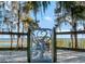 Custom metalwork gate and fence with scenic lake and dock view at 6320 Rocky Point Rd, Lake Wales, FL 33898