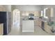 Well-lit kitchen features an island, black appliances, light wood cabinets, and tile flooring at 12859 Enclave Dr, Orlando, FL 32837