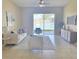 Bright living room showcasing tile floors, neutral paint, ceiling fan, and sliding glass door with pond view at 12859 Enclave Dr, Orlando, FL 32837