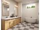 Modern bathroom design with dual sinks, a freestanding tub, and black and white checkered floor tiles at 1309 Errol Green Ct, Apopka, FL 32712