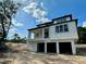 Modern home featuring an elevated design, with a covered porch, multiple windows, and a spacious garage underneath at 1309 Errol Green Ct, Apopka, FL 32712