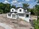 New construction home showcasing a modern farmhouse design with white siding and a dark roof at 1309 Errol Green Ct, Apopka, FL 32712