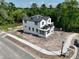 New two-story home under construction with a black tile roof and white siding, surrounded by lush greenery at 1309 Errol Green Ct, Apopka, FL 32712