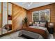 This bedroom includes wood walls, a ceiling fan, large windows, and natural light at 7200 Grace Rd, Orlando, FL 32819