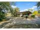 Exterior view of a carport featuring a boat and trailer, surrounded by lush landscaping and a sunny blue sky at 7200 Grace Rd, Orlando, FL 32819