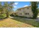 A two-story home featuring a tan exterior with white-framed windows and landscaped grounds at 7200 Grace Rd, Orlando, FL 32819