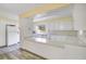 Well-lit kitchen features white cabinets, grey wood flooring, and a window overlooking the backyard at 7200 Grace Rd, Orlando, FL 32819