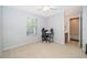 Bedroom with a desk, ceiling fan, and large window near an open door to a bathroom at 11313 Via Andiamo, Windermere, FL 34786
