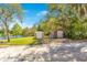 Two outbuildings near a tranquil lake on a grassy lawn under mature trees at 45 Sackett Rd, Debary, FL 32713