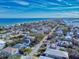 An aerial view showcases a vibrant coastal community with stunning ocean views and a mix of residential homes at 6353 River Rd, New Smyrna Beach, FL 32169
