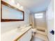 Bathroom features a large mirror, vanity with sink, toilet, and tiled shower-tub combo at 6353 River Rd, New Smyrna Beach, FL 32169